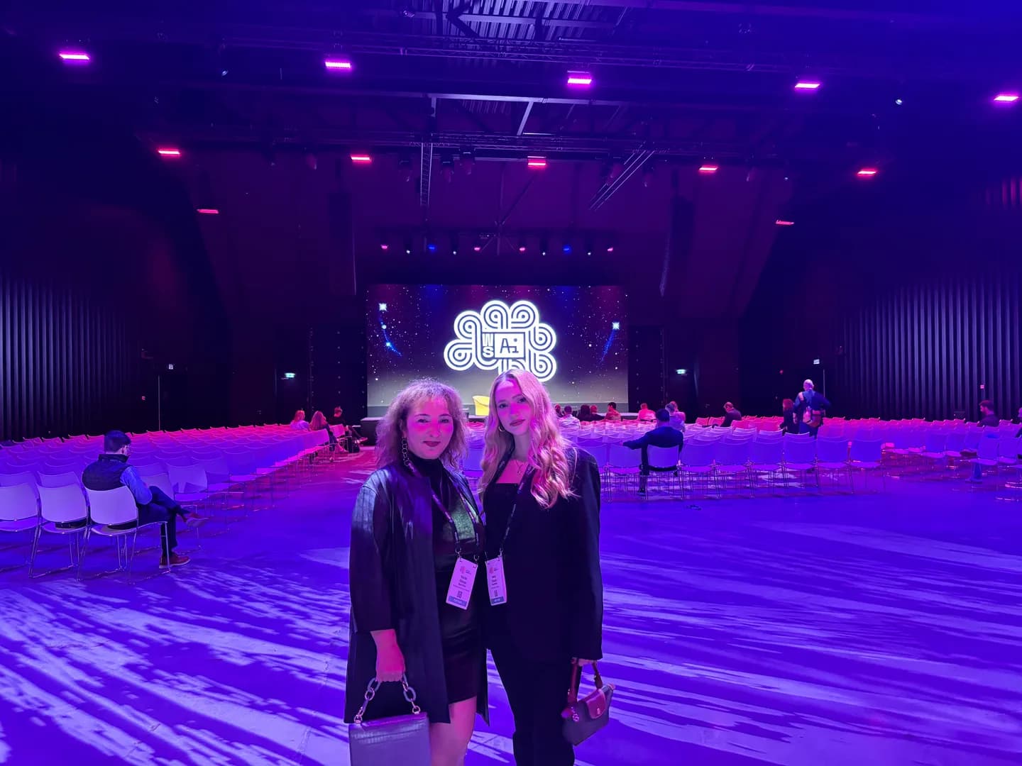 Two attendees in front of the illuminated World Summit AI stage