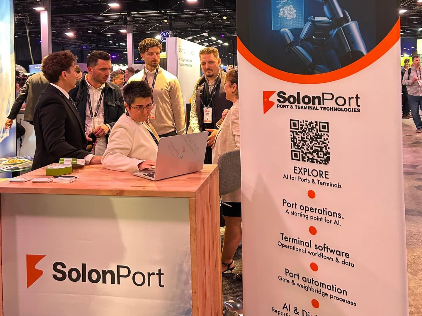 Attendees gathered around a laptop at the SOLONPORT stand at World Summit AI 2026